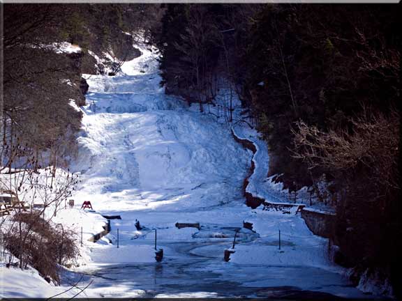 Photograph of Buttermilk Falls dappled n winter sunlight.